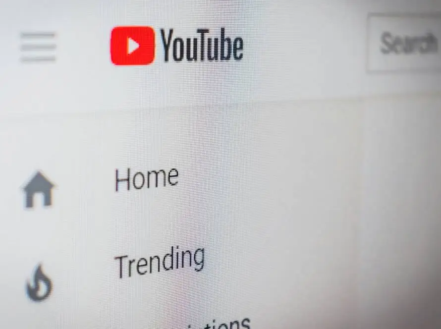 Close-up of a computer screen showing the YouTube logo at top left. Below, navigation menu options—Home, Trending, and Subscriptions—appear, as seen on a healthcare SEO tutorial by a leading healthcare digital marketing agency. The rest is blurred and out of focus.