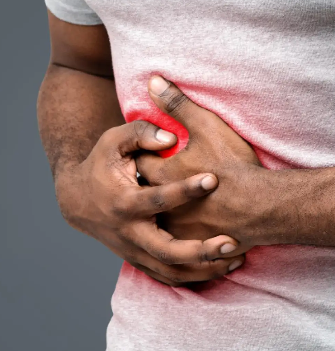 A person wearing a light grey shirt clutches their abdomen with both hands, showing discomfort or pain. A red glowing area is digitally highlighted on their stomach, suggesting abdominal pain or cramps—common symptoms explored in medical case studies.